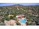 Expansive aerial view of a luxury estate with a large pool, lush greenery, and mountain views at 7723 E Visao Dr, Scottsdale, AZ 85266