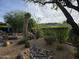 Backyard oasis featuring desert landscaping, a fire pit, and lush greenery for outdoor enjoyment at 7723 E Visao Dr, Scottsdale, AZ 85266