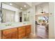Bathroom featuring double sinks, wood cabinets, neutral colors, and view into the bedroom at 7723 E Visao Dr, Scottsdale, AZ 85266