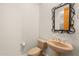 Powder room featuring a decorative mirror, pedestal sink, and neutral-toned fixtures for a clean, classic look at 7723 E Visao Dr, Scottsdale, AZ 85266