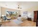 Bright bedroom with large window, ceiling fan, sitting area, and beautiful light wood floors at 7723 E Visao Dr, Scottsdale, AZ 85266