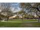 Scenic lawn area with mature trees, walking paths and desert landscaping in the background at 7723 E Visao Dr, Scottsdale, AZ 85266