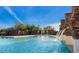 Sparkling community pool with stone features, cascading water, and a beautiful backdrop of mature trees at 7723 E Visao Dr, Scottsdale, AZ 85266