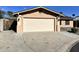 Attached two-car garage with tan door and desert landscaping in front of this single-story home at 10223 N 40Th Ave, Phoenix, AZ 85051