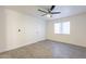 This bedroom features wood-look tile floors, a ceiling fan, a window and a white door at 10828 N Biltmore Dr # 113, Phoenix, AZ 85029