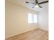 This bedroom features wood-look tile floors, a ceiling fan, and a window at 10828 N Biltmore Dr # 113, Phoenix, AZ 85029