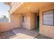 A view of the private front porch and entrance; complete with a sliding window and tan stucco walls at 10828 N Biltmore Dr # 113, Phoenix, AZ 85029