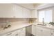 Renovated kitchen boasts white countertops, updated cabinetry, and stainless steel appliances at 10828 N Biltmore Dr # 113, Phoenix, AZ 85029