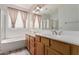 Bathroom with a double sink vanity, tub, and glass block window at 12841 N 19Th St, Phoenix, AZ 85022