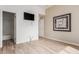 Bedroom featuring wood-look floors, mounted TV, closet, and access to a bathroom at 12841 N 19Th St, Phoenix, AZ 85022