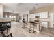 Open-concept kitchen with granite countertops, white cabinets, stainless steel appliances, island with barstool seating and views of the living area at 12841 N 19Th St, Phoenix, AZ 85022