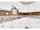 Well-equipped kitchen with white cabinets, granite counters, and cooktop at 1289 E Palo Blanco Way, Gilbert, AZ 85296