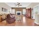Bright living room featuring a fireplace, hardwood floors, plantation shutters, and a contemporary ceiling fan at 1289 E Palo Blanco Way, Gilbert, AZ 85296