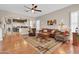 Spacious living room boasts hardwood floors, a ceiling fan, neutral paint, and an open layout to the kitchen at 1289 E Palo Blanco Way, Gilbert, AZ 85296
