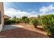 Lush backyard featuring green shrubs, mature trees and brick pavers, creating a private outdoor space at 12930 W Chapala Dr, Sun City West, AZ 85375