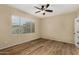 Bright bedroom featuring wood-look floors, neutral walls, and a ceiling fan for comfortable living at 12930 W Chapala Dr, Sun City West, AZ 85375