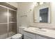 Bathroom features a shower, toilet, sink with neutral countertop, and vanity mirror at 13148 N 21St Ave, Phoenix, AZ 85029