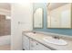 Updated bathroom with dual sinks, white cabinets, framed mirrors and a tiled tub/shower combo at 13148 N 21St Ave, Phoenix, AZ 85029