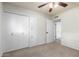Bedroom featuring closet, door to another room, neutral carpet, and ceiling fan at 13148 N 21St Ave, Phoenix, AZ 85029