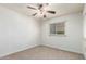Bright bedroom with a ceiling fan, a window with blinds, and neutral carpet at 13148 N 21St Ave, Phoenix, AZ 85029
