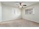 Neutral bedroom features a ceiling fan, natural light, and cozy carpeting at 13148 N 21St Ave, Phoenix, AZ 85029