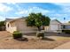 View of the front of the house with a mature tree, rock landscaping, and a two-car garage at 13148 N 21St Ave, Phoenix, AZ 85029