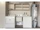 Laundry room includes a washer, dryer, utility sink, and shelving at 13148 N 21St Ave, Phoenix, AZ 85029