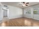 Spacious living room featuring hardwood floors, abundant natural light, and a ceiling fan at 13148 N 21St Ave, Phoenix, AZ 85029