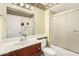 Well-lit bathroom with a white sink and countertop, a large mirror, and a glass-enclosed shower-tub combination at 13630 W Aleppo Dr, Sun City West, AZ 85375