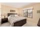 Cozy bedroom with a comfortable bed, neutral walls, a window, and a nightstand with lamps at 13630 W Aleppo Dr, Sun City West, AZ 85375