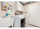 Functional laundry room featuring a washing machine, dryer, sink, cabinets and space for laundry tasks at 13630 W Aleppo Dr, Sun City West, AZ 85375