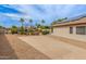 Wide backyard showcasing a concrete area, desert plants, patio and solar panels on the roof at 14374 W Amelia Ave, Goodyear, AZ 85395