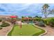 Beautiful backyard features a pool, putting green, patio furniture, and lush landscaping, ideal for outdoor living at 14374 W Amelia Ave, Goodyear, AZ 85395