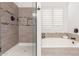 Tiled bath and shower with plantation shutters at 14374 W Amelia Ave, Goodyear, AZ 85395