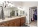 Ensuite bathroom with double vanity, granite countertop and walk-in closet at 14374 W Amelia Ave, Goodyear, AZ 85395