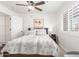 Bright bedroom with shuttered windows, ceiling fan and a neatly arranged bed and side table at 14374 W Amelia Ave, Goodyear, AZ 85395