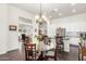 Open-concept dining area with a glass table, chandelier lighting, and seamless flow into the kitchen at 14374 W Amelia Ave, Goodyear, AZ 85395