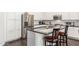 Bright kitchen with stainless steel appliances, a breakfast bar, dark countertops, and sleek white cabinetry at 14374 W Amelia Ave, Goodyear, AZ 85395