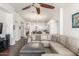 Spacious living room with large sectional, open floorplan and ceiling fan at 14374 W Amelia Ave, Goodyear, AZ 85395