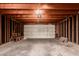 Unfinished garage interior showcasing exposed wooden beams, concrete floor, and garage door at 1535 N Horne -- # 35, Mesa, AZ 85203