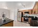 Corner view of kitchen showcases black countertops, oak cabinets, and stainless steel appliances at 1535 N Horne -- # 35, Mesa, AZ 85203