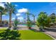 Inviting backyard featuring a sparkling pool, lush turf, desert landscaping, and mature palm trees at 15430 N 51St Pl, Scottsdale, AZ 85254