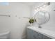 Clean bathroom featuring a vanity with storage, large round mirror, and modern lighting at 15430 N 51St Pl, Scottsdale, AZ 85254