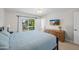 Bedroom features sliding glass doors to backyard, a dresser, TV, and light-colored walls at 15430 N 51St Pl, Scottsdale, AZ 85254
