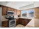 Well-lit kitchen with granite countertops, stainless steel appliances, and ample cabinet space for storage at 15430 N 51St Pl, Scottsdale, AZ 85254