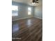 Bright bedroom with two windows, modern ceiling fan, and beautiful wood flooring at 1615 W Michelle Dr, Phoenix, AZ 85023