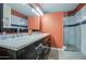 Renovated bathroom featuring double sinks, a marble countertop, and a tiled shower at 1853 W Estrella Dr, Chandler, AZ 85224