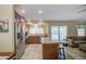 Well-lit kitchen with stainless steel appliances, island with granite countertop, and easy access to living room at 1853 W Estrella Dr, Chandler, AZ 85224