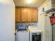 Cozy laundry room features wood cabinets, stacked washer and dryer, and convenient shelving for storage at 1853 W Estrella Dr, Chandler, AZ 85224