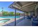 Covered patio overlooking a sparkling pool and lush backyard, ideal for outdoor dining and relaxation at 1853 W Estrella Dr, Chandler, AZ 85224
